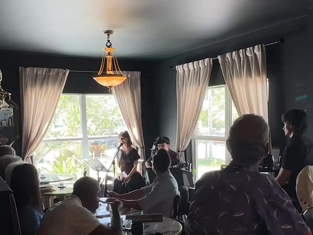 A full café on Sunday: guests at tables listening to the band by the windows